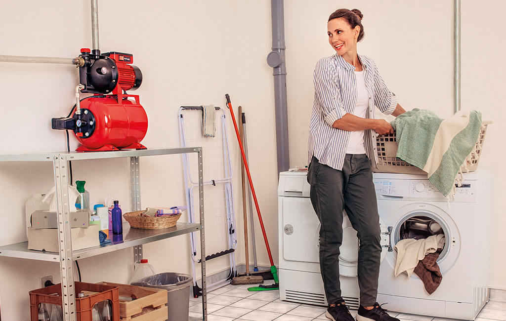 Eine Frau leert eine Waschmaschine, die an ein Wasserwerk angeschlossen ist.