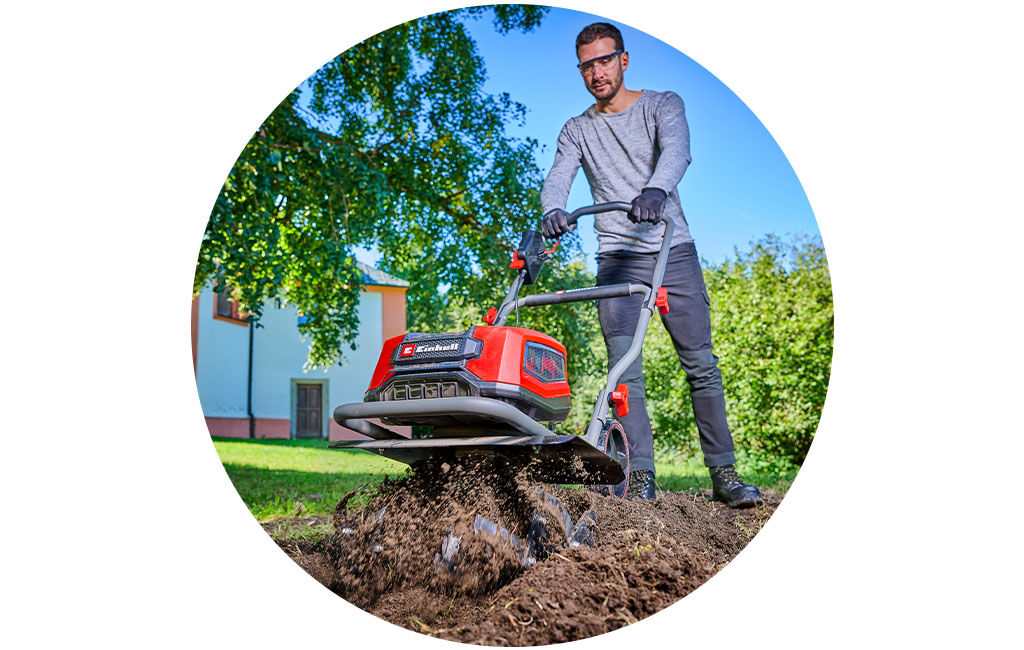 A man works with the Einhell rotary tiller