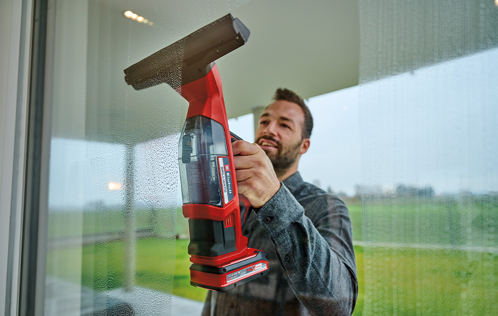 ein Mann putzt ein Fenster mit dem Einhell Akku-Fensterreiniger BRILLIANTO