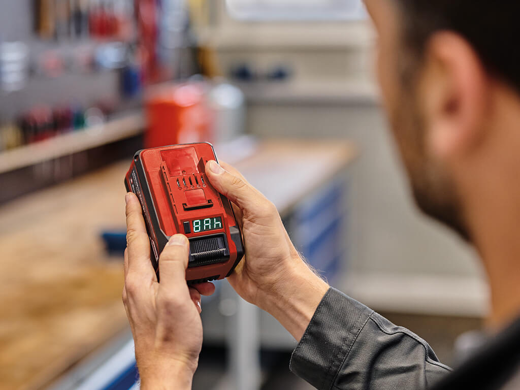 A man changing the Ah setting of his Power X-Change Multi-Ah battery to 8 Ah.