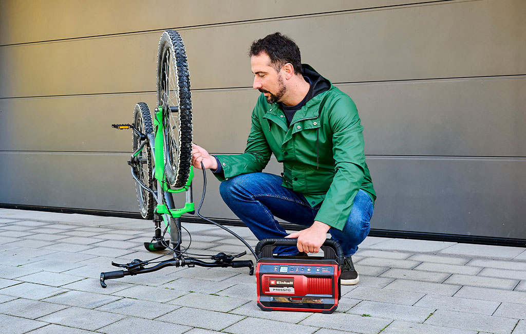 a man pumps up the tyres of a bicycle