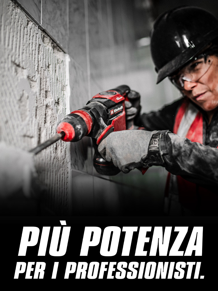 Una persona con occhiali di sicurezza e casco utilizza un trapano rosso su una parete, con il testo "Più potenza per i professionisti".